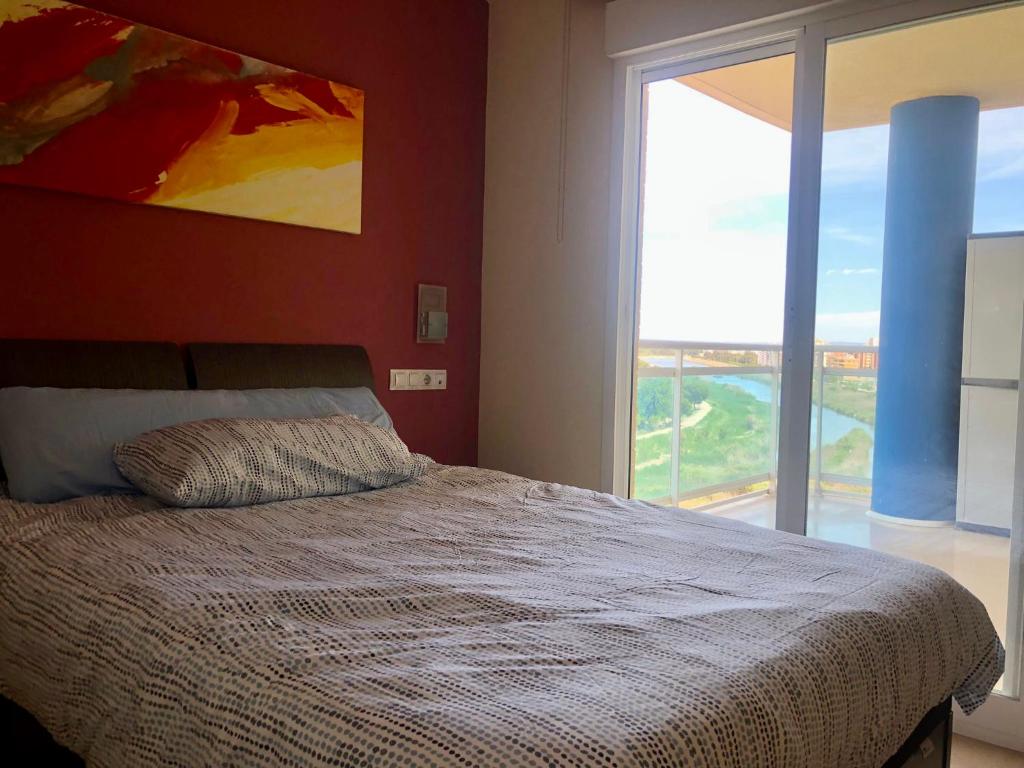 ein Schlafzimmer mit einem Bett und einem großen Fenster in der Unterkunft Schöne Wohnung mit Top Aussicht in Guardamar del Segura