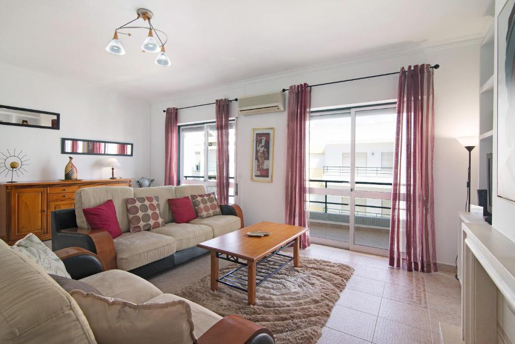 - un salon avec un canapé et une table dans l'établissement Apartamento Kaya, à Albufeira