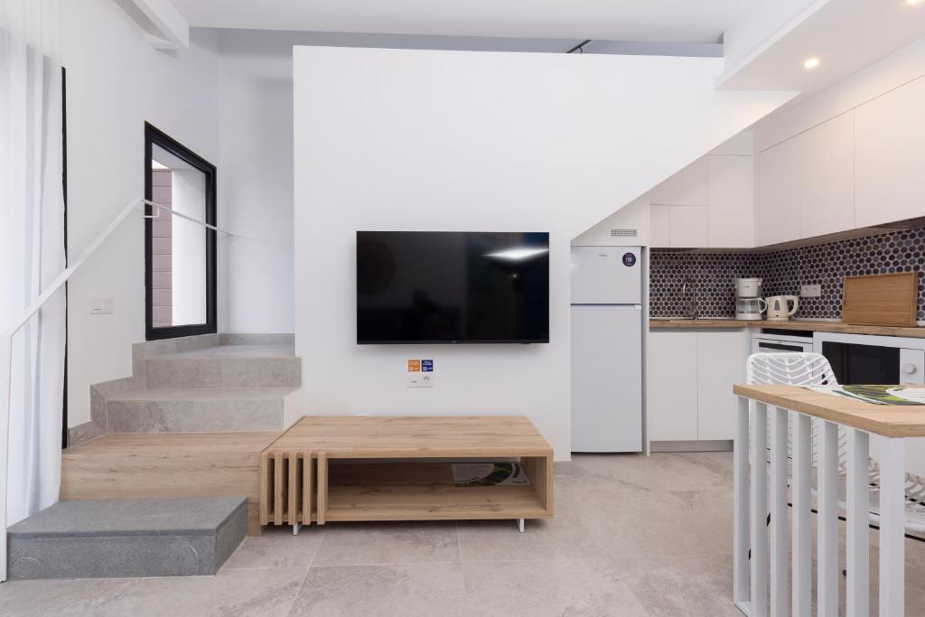 a living room with a tv and a table at Esmeralda Cotillo Homes by LIVVO in El Cotillo