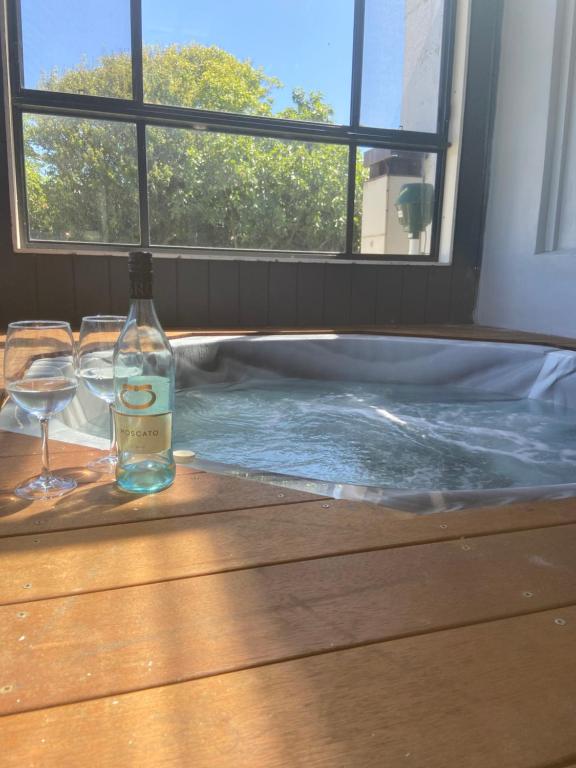 - une bouteille de vin et des verres assis sur une table dans un bain à remous dans l'établissement Portland sea spa retreat, à Portland