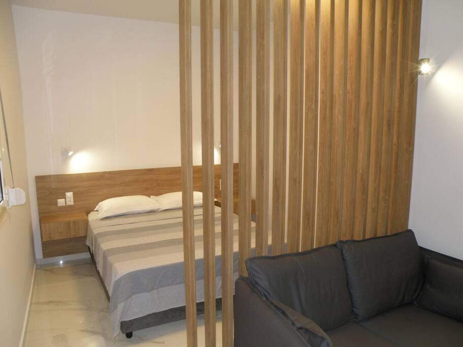 a bedroom with a bed and a couch at Modern lifestyle flat close to the sea. in Gázion