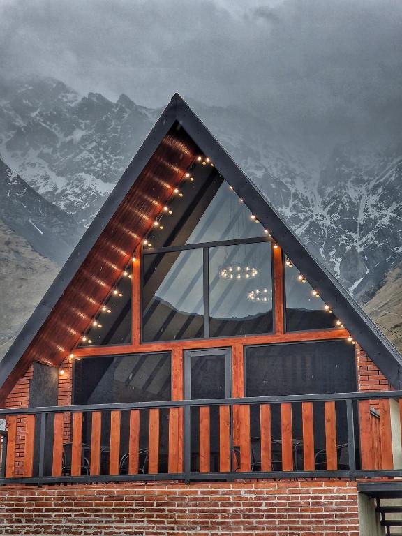 a house with a window and a snow covered mountain at Kazbegi Hut Cottage in Kazbegi