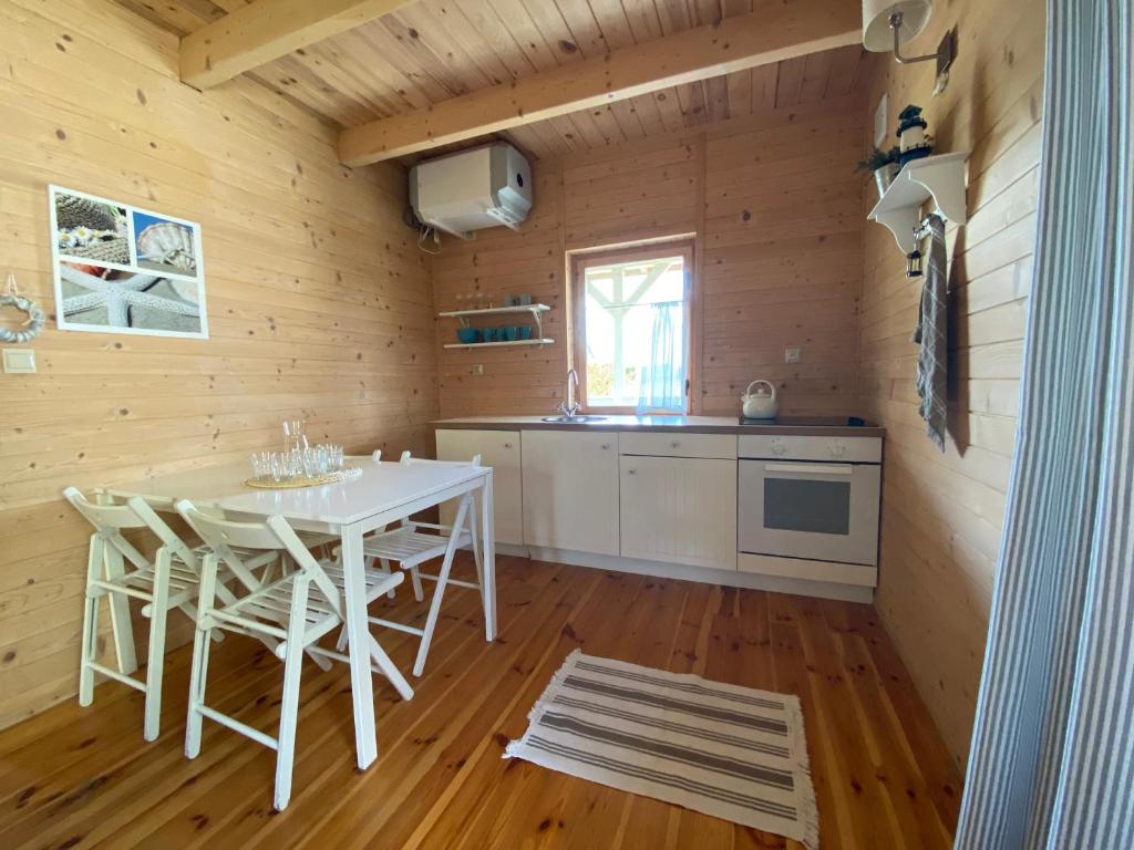 斯瓦澤沃的住宿－Morska Osada Swarzewo，小屋内的厨房配有白色的桌椅