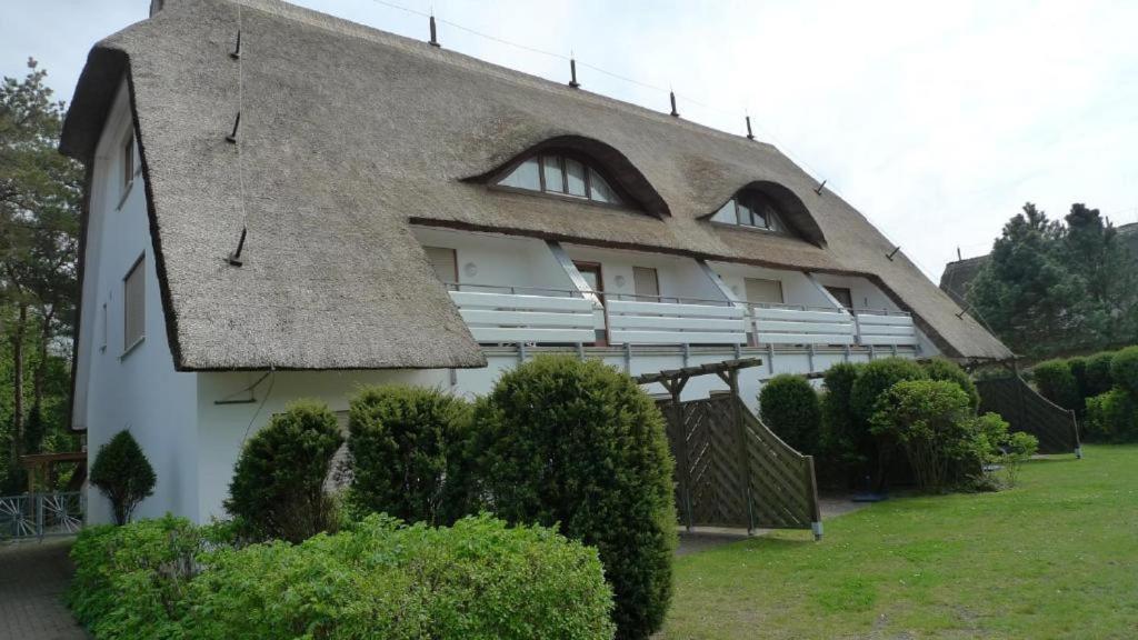a house with a thatched roof and some bushes at Appartementhaus "Susanne", Wohnung Seehund in Wustrow