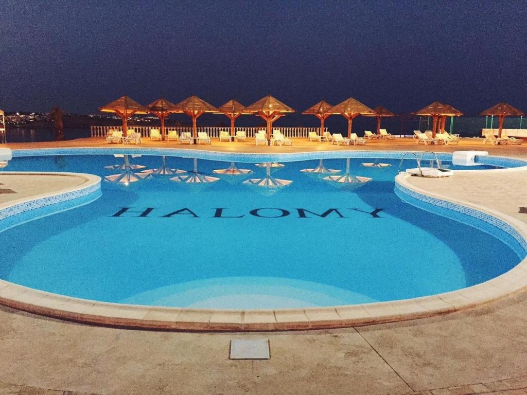 シャルム・エル・シェイクにあるHalomy Sharm Resortのホテルの看板が記載された大型スイミングプール