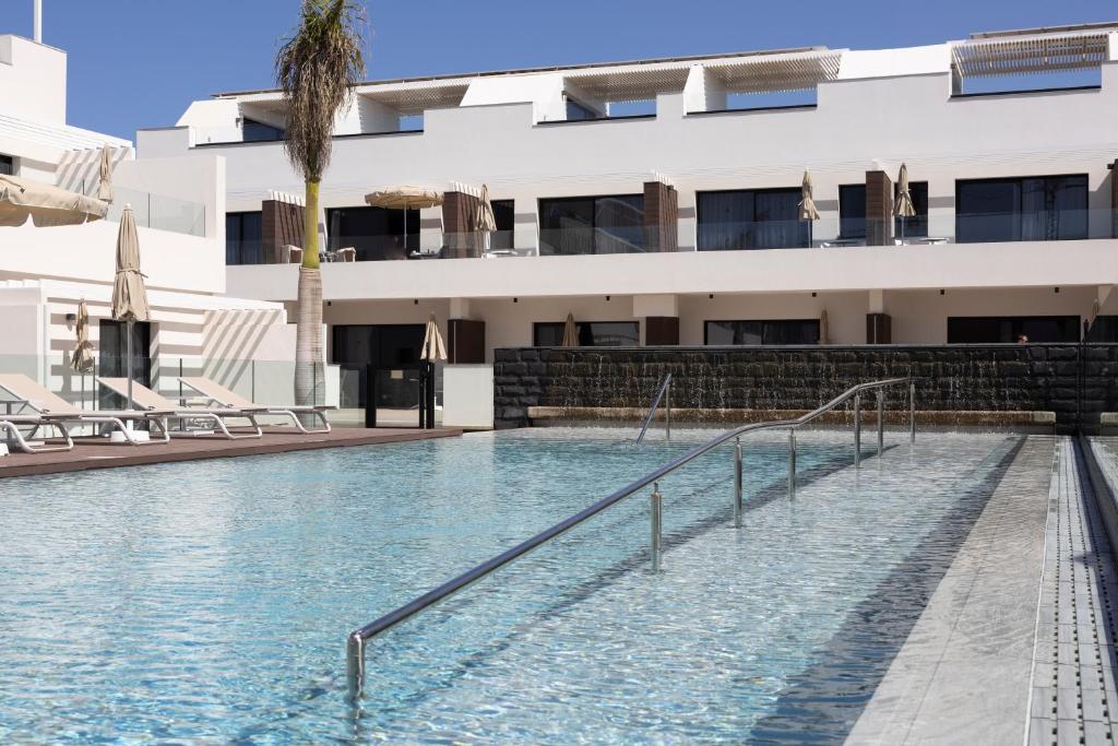 a swimming pool in front of a building at LACASA Apartments Cotillo in El Cotillo