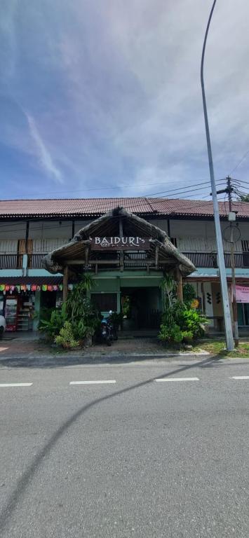 a building with a sign on the front of it at Baiduri's Place in Pantai Cenang