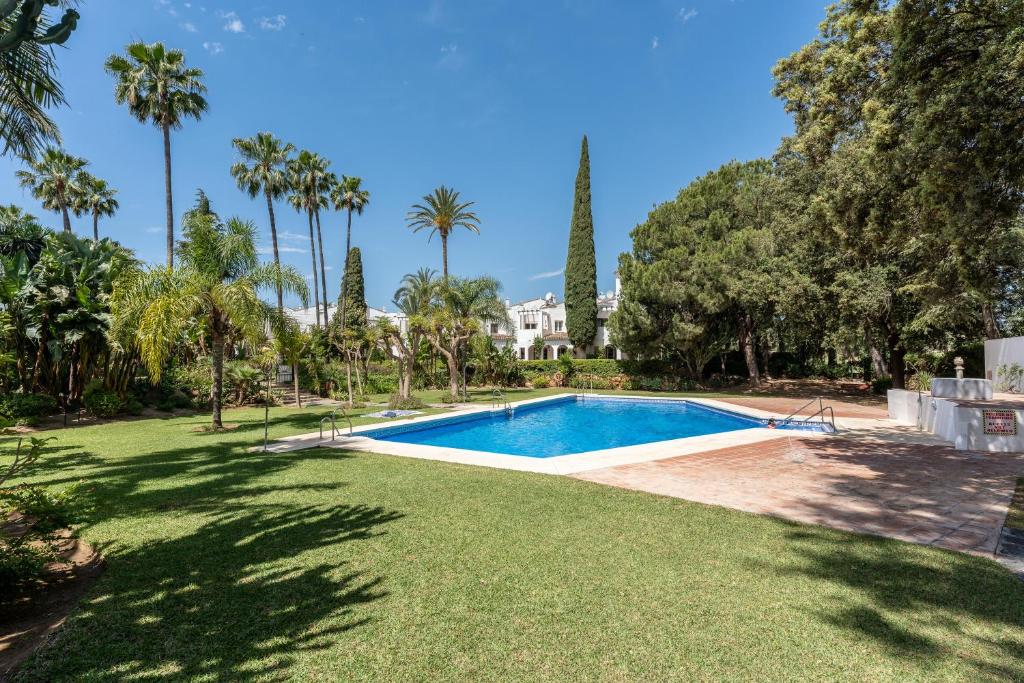 una piscina en un patio con palmeras en Casa Karma, en Mijas