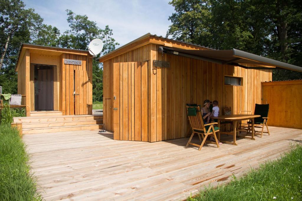 a wooden building with a table and people sitting at it at Bosruck Chalet in Misselsdorf