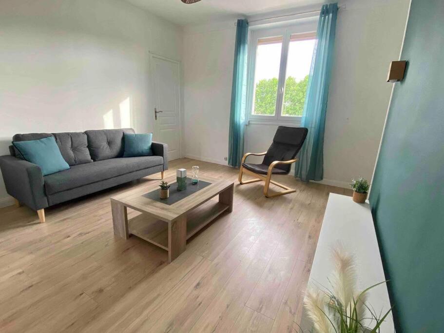 un salon avec un canapé et une table basse dans l'établissement Appartement proche des remparts - Avignon, à Avignon