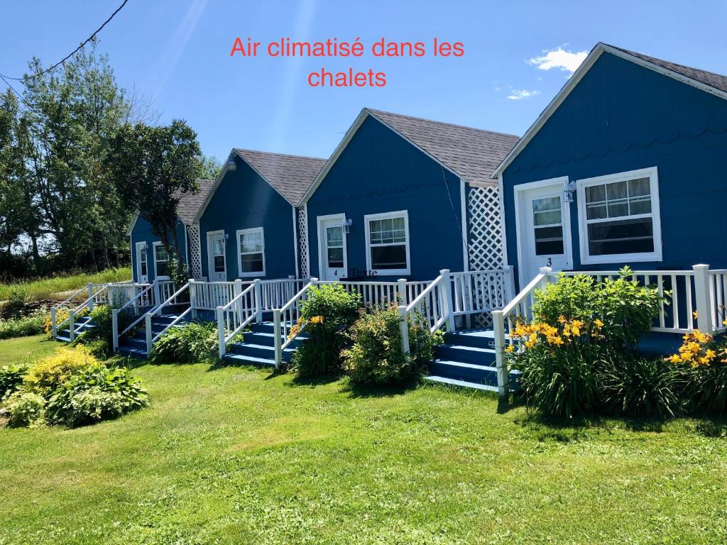 a row of blue houses in a yard w obiekcie Motel le repos w mieście Percé