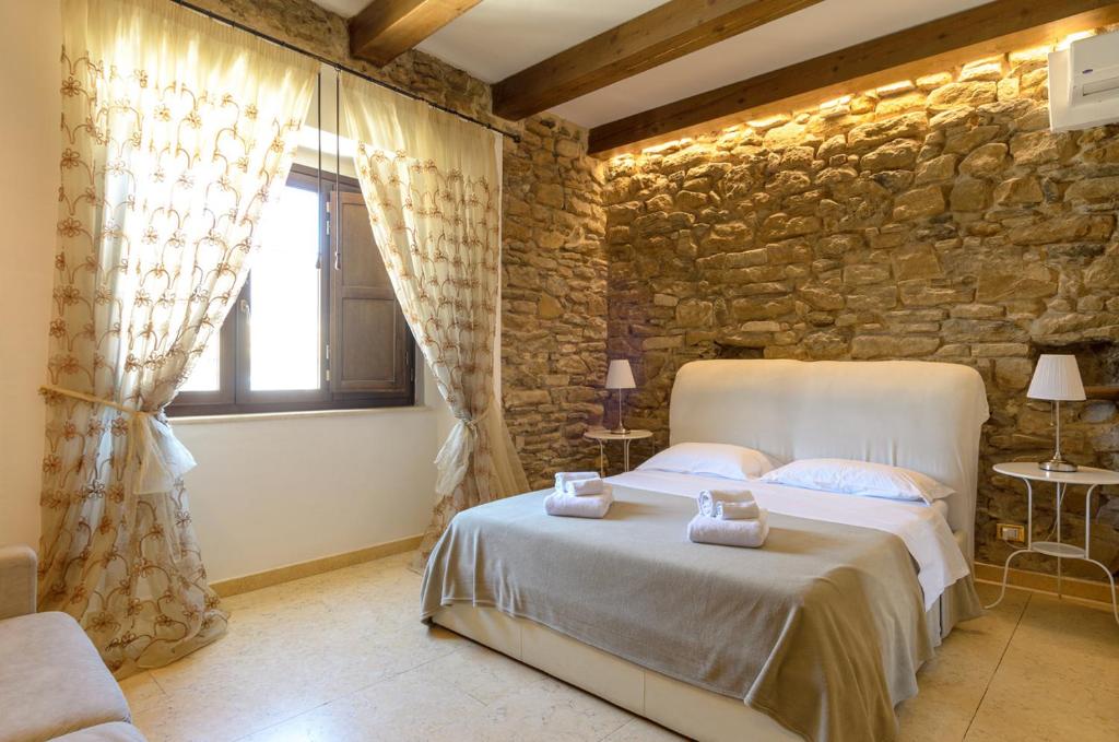 B&B Le Stanze di Ludovica في تيرمولي: غرفة نوم بسرير وجدار حجري