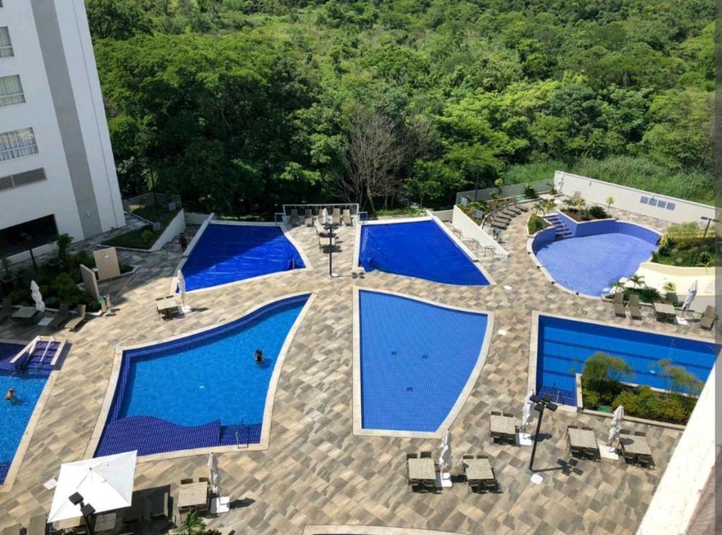 - une vue sur la piscine avec des piscines bleues dans l'établissement Park veredas Rio Quente Flavia, à Rio Quente