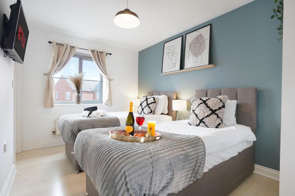 a bedroom with two beds and a table with drinks on it at Grange House with Free Parking, Garden, Superfast Wifi and Smart TVs with Netflix by Yoko Property in Northampton