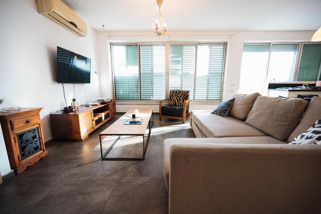 een woonkamer met een bank en een tafel bij spacious apartment in Tel Aviv
