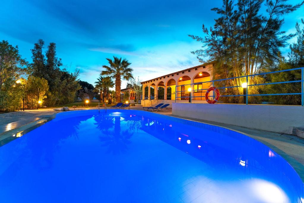 a large blue swimming pool in front of a building at Villas Mina in Gennadi