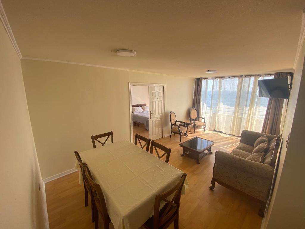sala de estar con mesa, sofá y habitación en Deptos y habitaciones en sector sur de Iquique, Chile, frente al mar, en Iquique