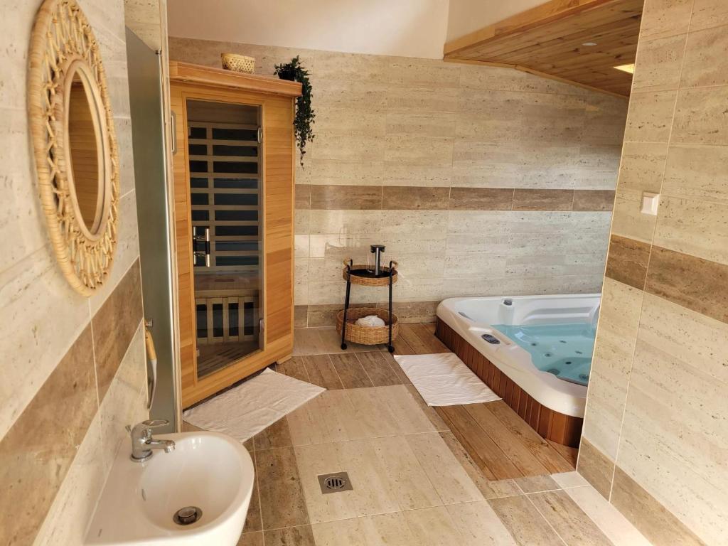 a bathroom with a tub and a toilet and a sink at Bodrogpart Vendégház Tokaj in Tokaj