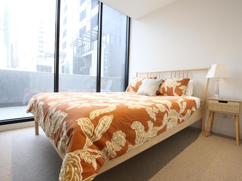 a bedroom with a bed and a large window at Dudley Cosy 2 beds 2 Baths with free parking in Melbourne