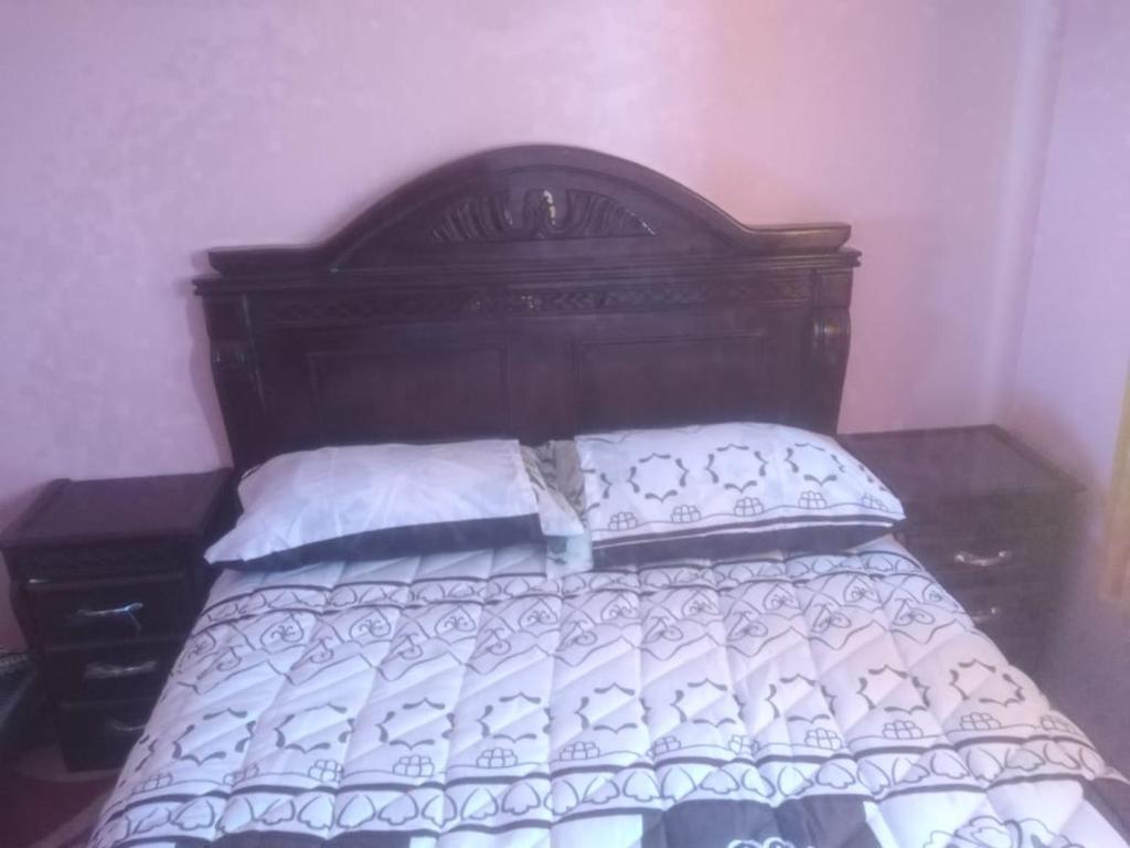 a bed with a wooden headboard in a bedroom at The beautiful view in Daher