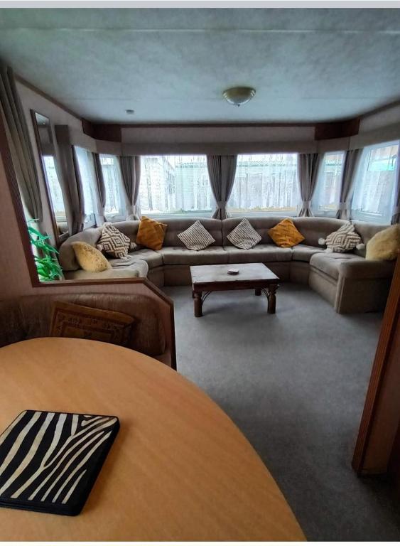 a living room with a couch and a table at Beautiful 2 bedroomed mobile home in Aberystwyth