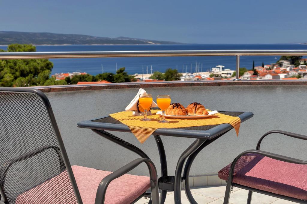 a table with a plate of bread and two glasses of orange juice at Villa Juric in Baška Voda
