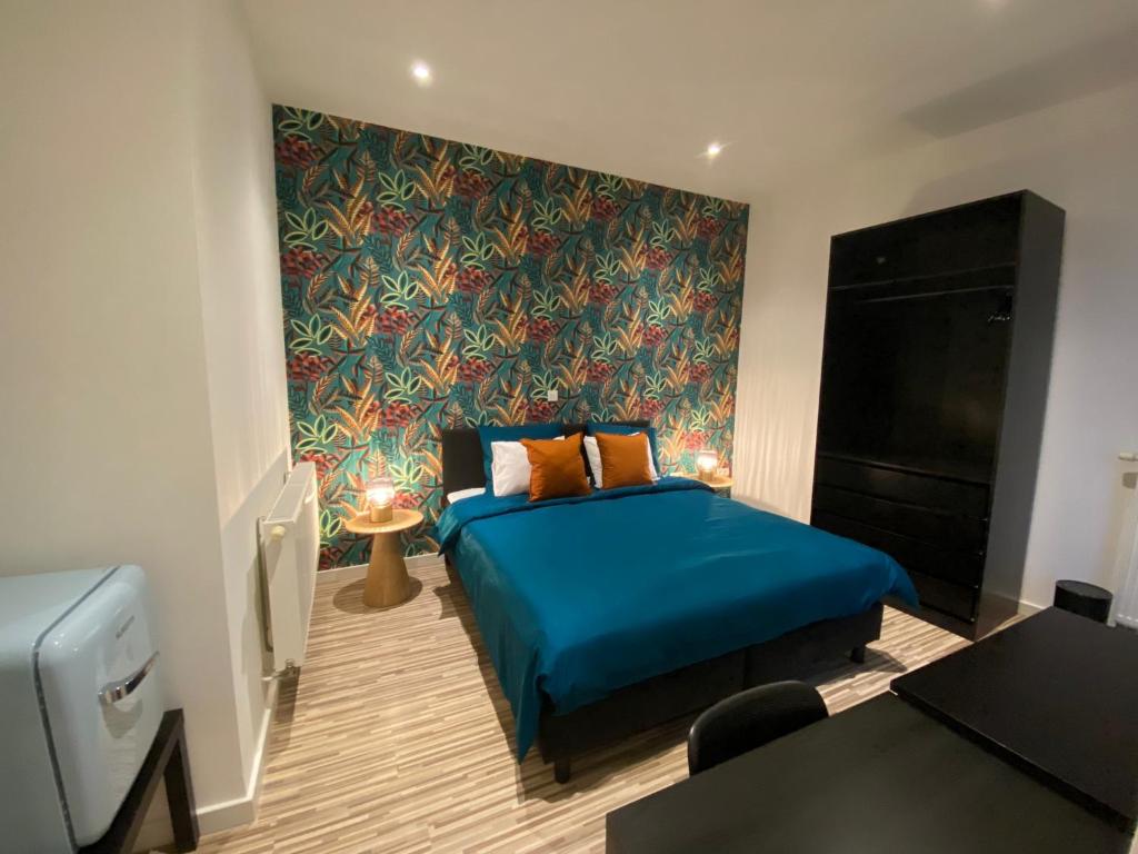 een slaapkamer met een blauw bed en een muur bij “De Koelemert” in Aalst