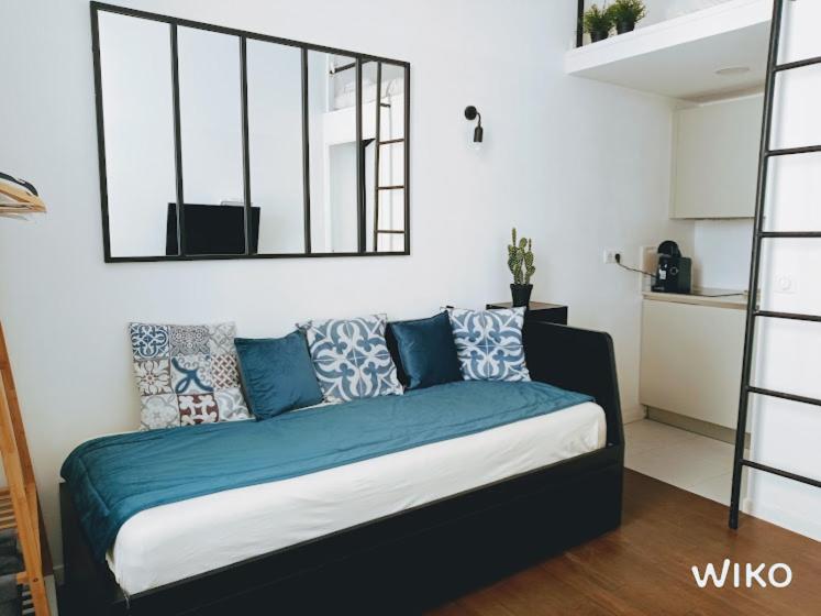 昂蒂布的住宿－STUDIO VIEIL ANTIBES Marché Provençal，一间卧室配有一张带蓝色枕头和镜子的床