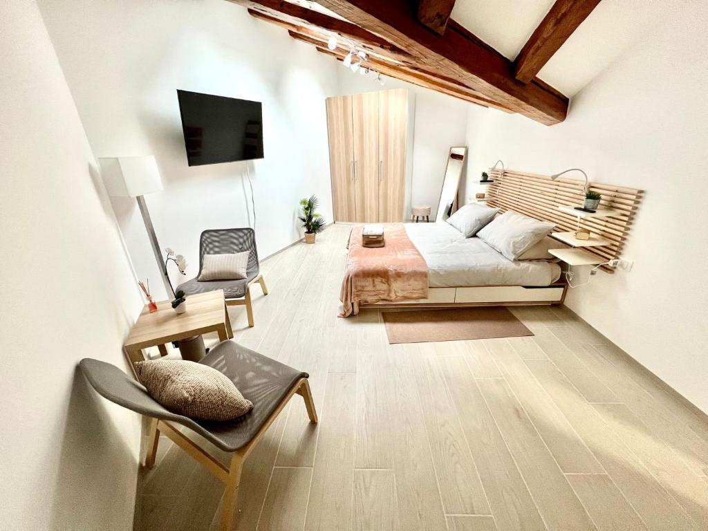 a bedroom with a bed and a tv and a chair at Perfect Stay Apartments in Trieste