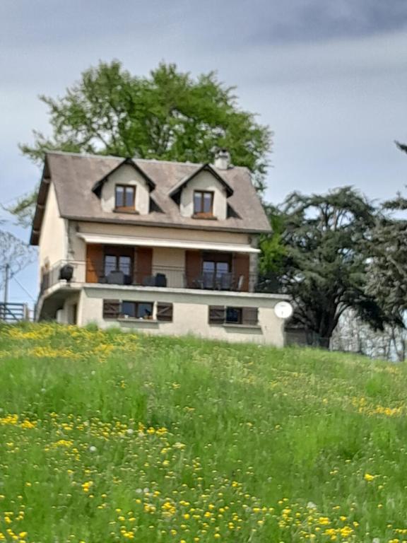 una casa in cima a una collina con un campo di fiori di Gite Au Bout du Monde 