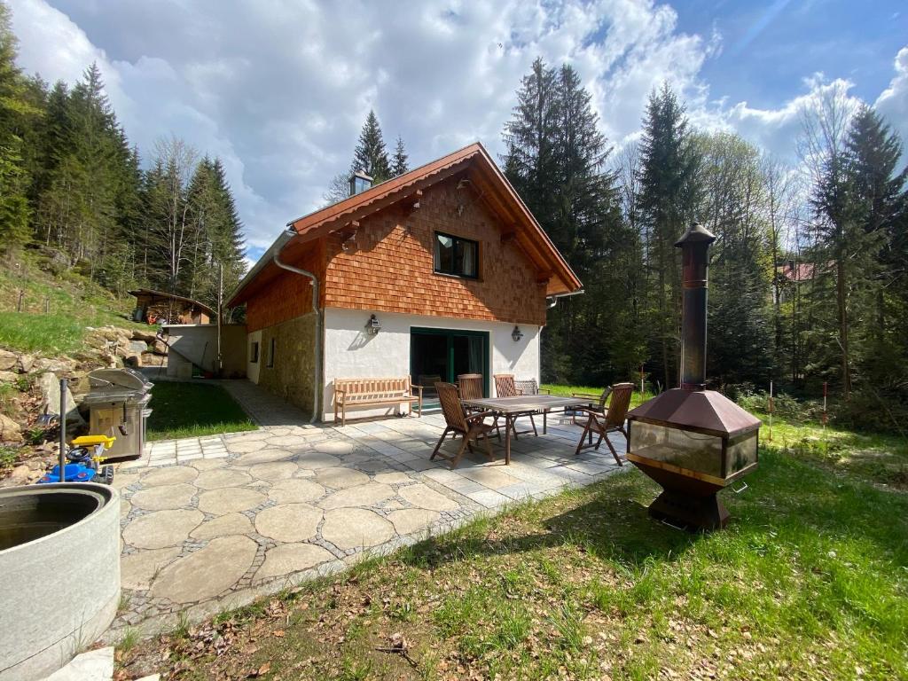 a house with a patio with a table and a grill at Das Hexenhaus: Haus im Wald in Rinchnach