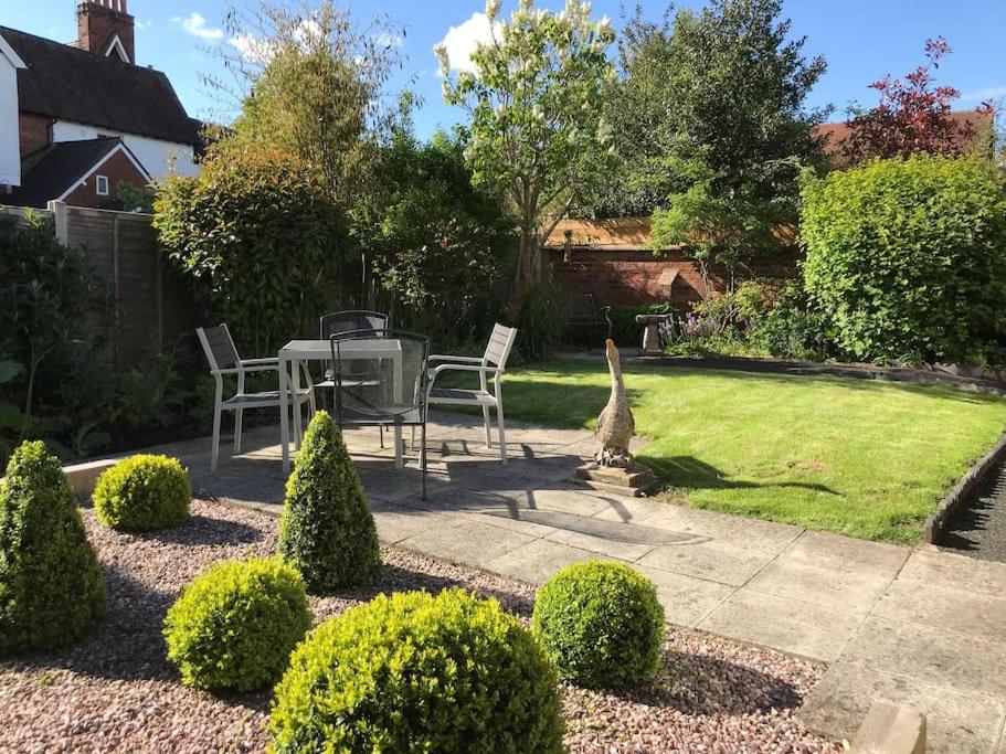 a garden with a table and chairs and a lawn at The Marches, Ludlow in Ludlow