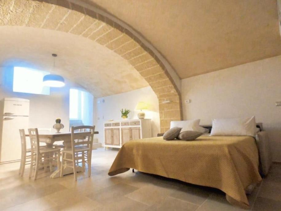 Cet appartement comprend une chambre avec un lit et une cuisine avec une table. dans l'établissement Casa Dogana, à Gallipoli