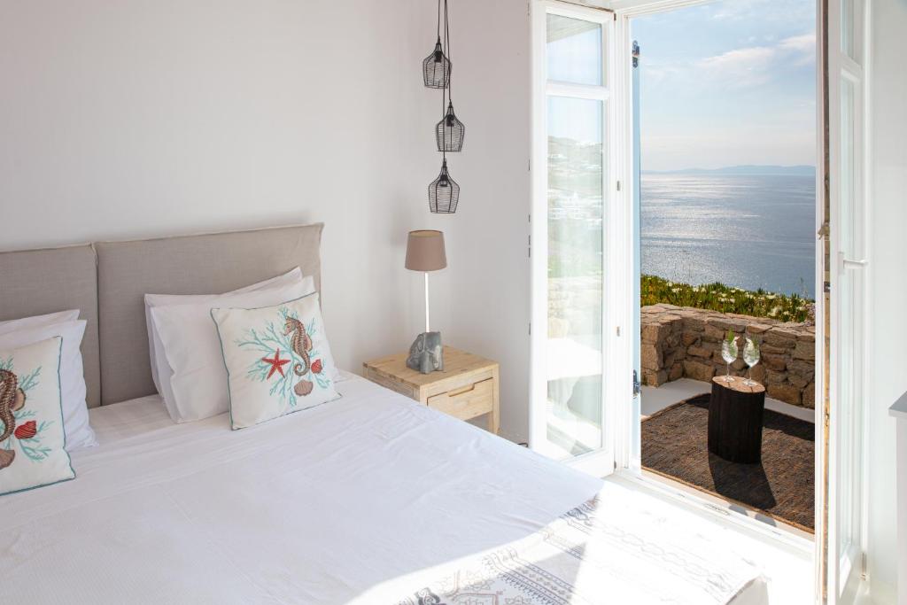 een slaapkamer met een bed en uitzicht op de oceaan bij Villa Mandala in Mykonos-stad