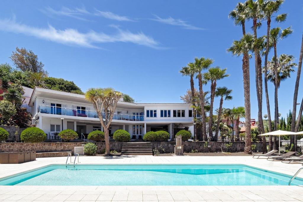 una casa con piscina y palmeras en La Ideal Mansion by VillaGranCanaria, en Tafira