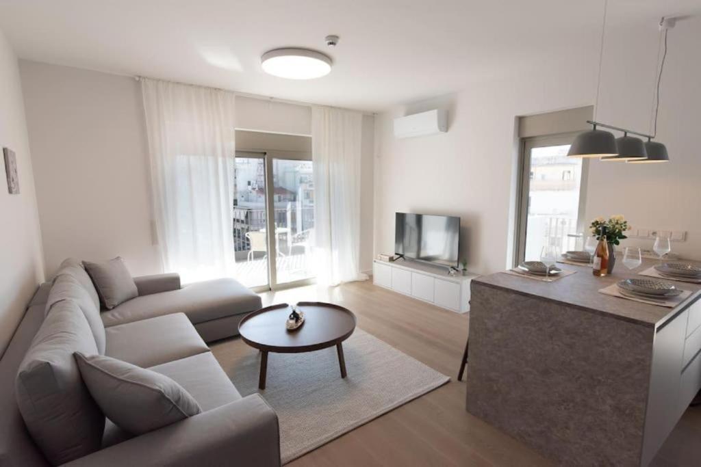 uma sala de estar com um sofá e uma mesa em Bright apartment in the New building (FORM_F1) em Atenas