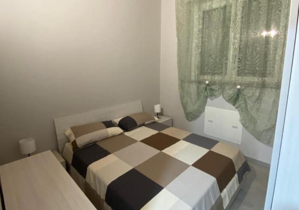 a bedroom with a bed and a window with curtains at BnB Martorelli in Turin