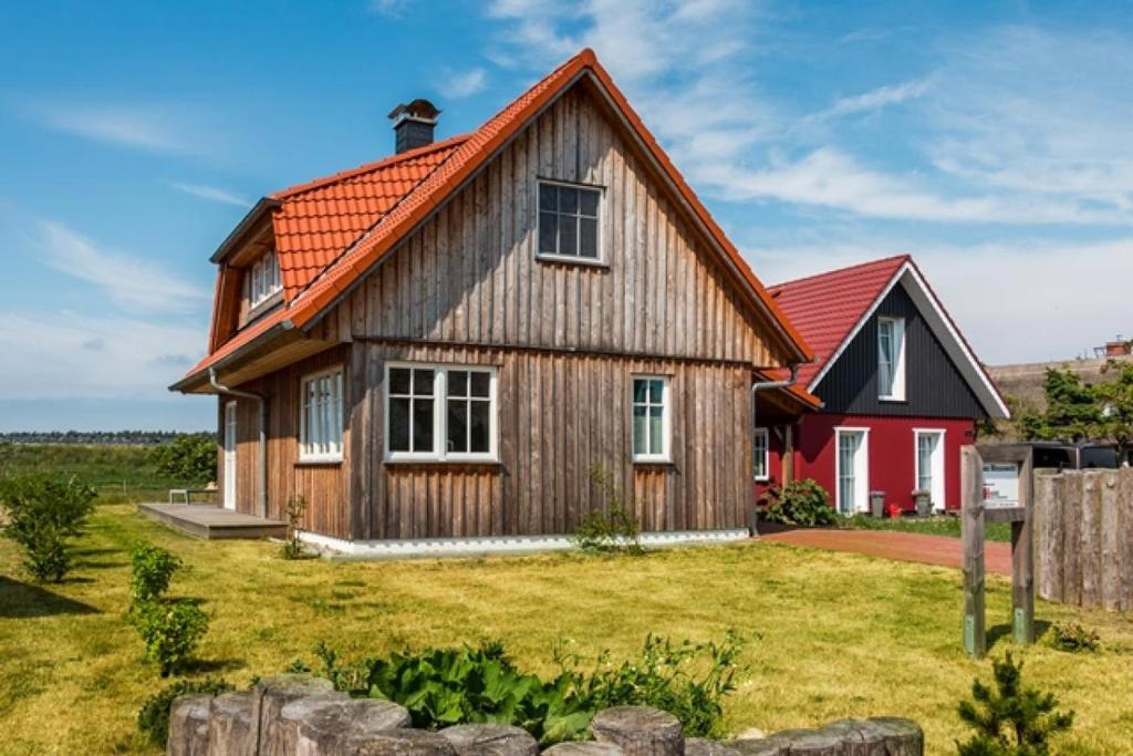 a large wooden house with a red roof at Haus Wiesenweite in Born