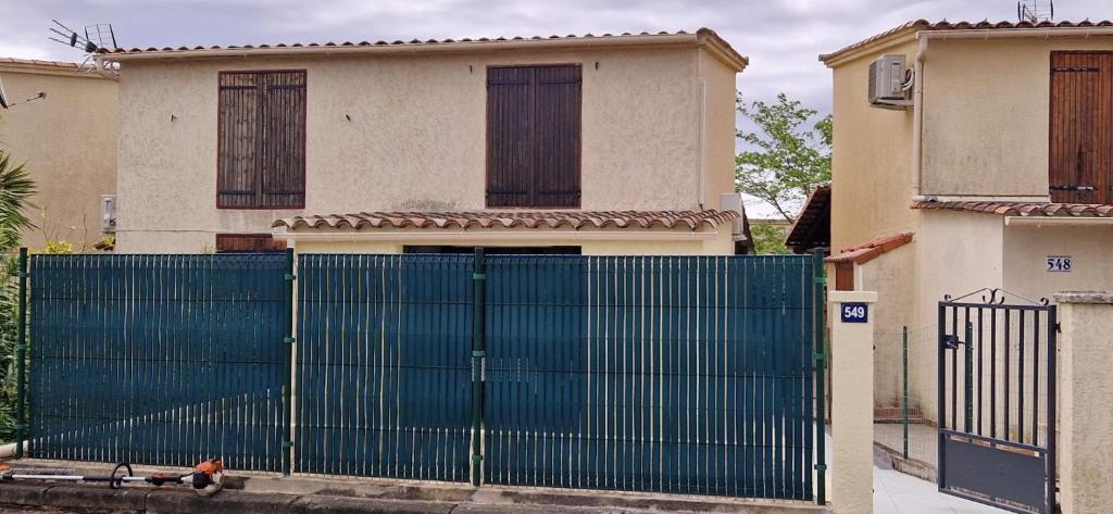 une porte bleue devant une maison dans l'établissement Mini villa au bord de la mer, proche Moriani (Corse), à Poggio-Mezzana