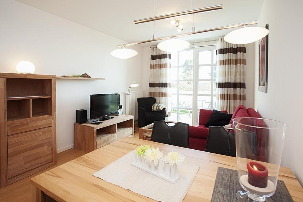 a living room with a table and a living room with a couch at Residenz am Balmer See - BS 01 mit Wellnessbereich in Balm