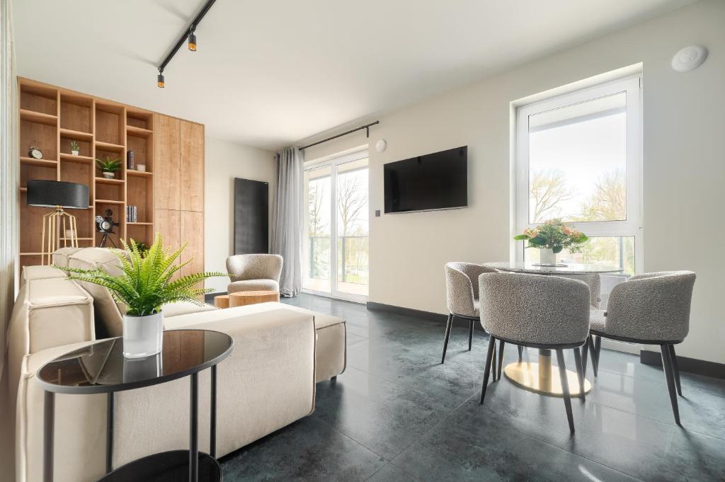 a living room with a couch and a table at Bridge Apartments & Spa Dziwnów in Dziwnów