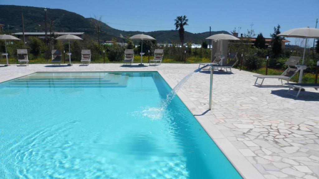 uma grande piscina com cadeiras e guarda-sóis em Il Sentiero di Leano em Terracina
