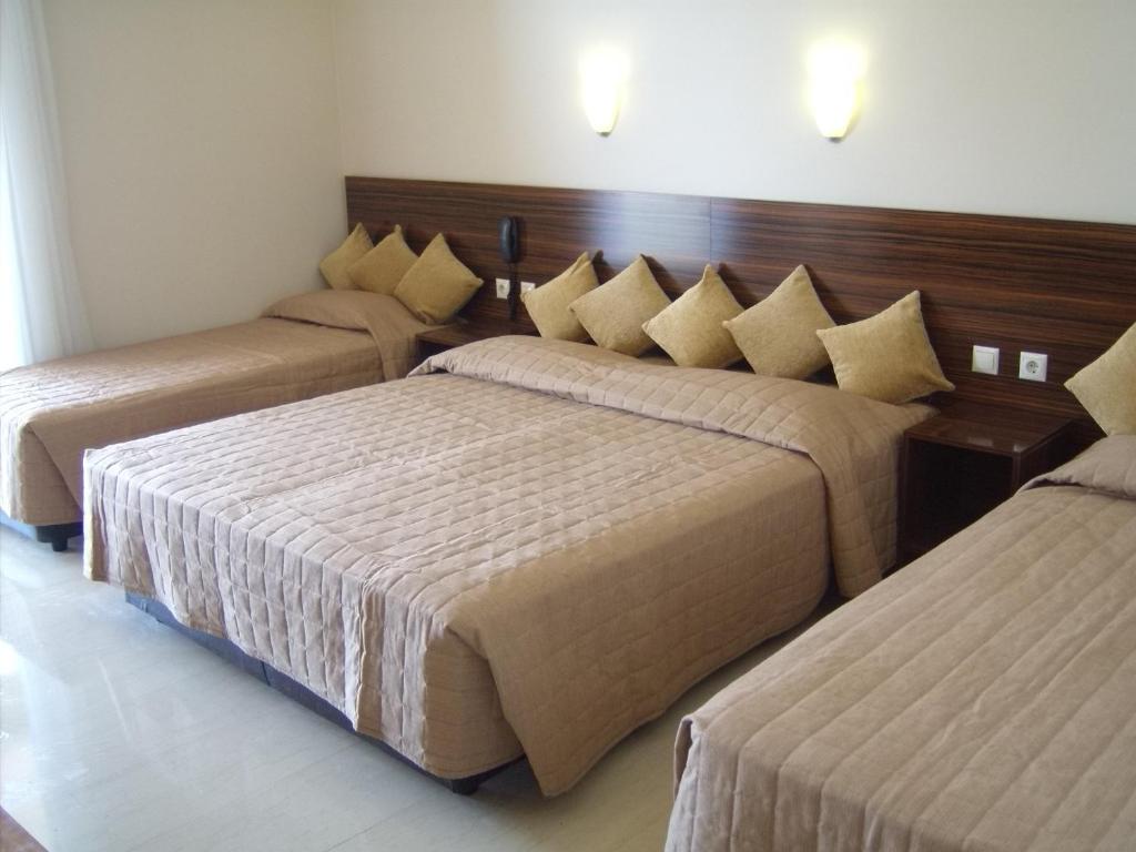 a hotel room with three beds in a room at Thea Hotel in Possidi