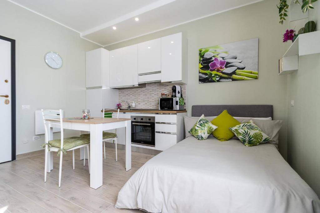 1 dormitorio con cama, mesa y cocina en [Monza-Station] Wi-Fi e Smart-TV., en Monza