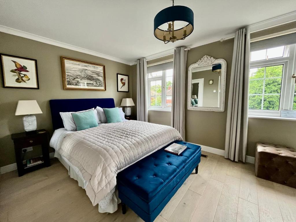 a bedroom with a blue bed and a blue ottoman at En-suite luxury large bedroom with parking and two tickets to Kew Gardens in Kew Gardens