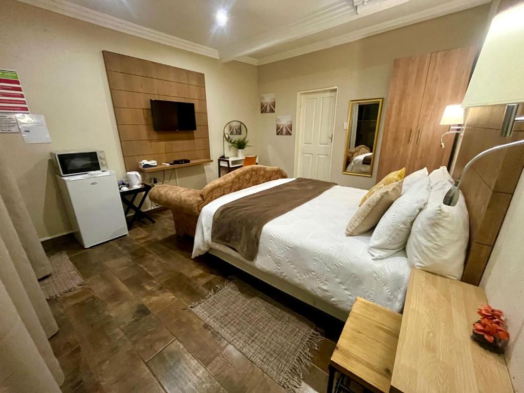 um quarto de hotel com uma cama e uma televisão em Swane’s guesthouse em Rustenburg