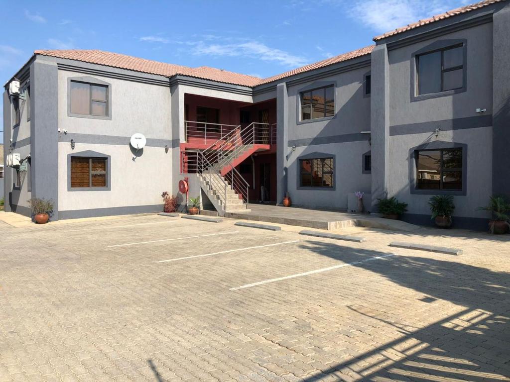 a large building with a staircase in a parking lot at Sekaka Fully Furnished Apartments in Gaborone