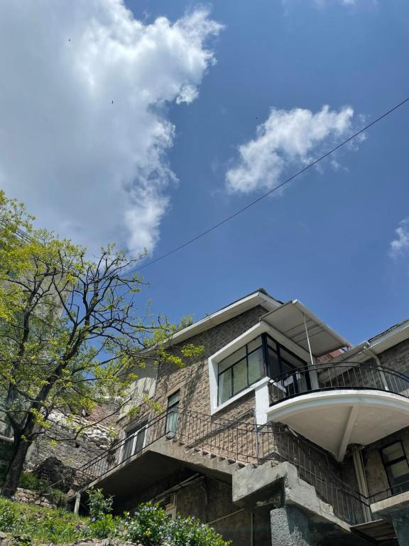 una casa con balcón en la parte superior en LOKAL Rooms x Murree Kashmir Point, en Murree