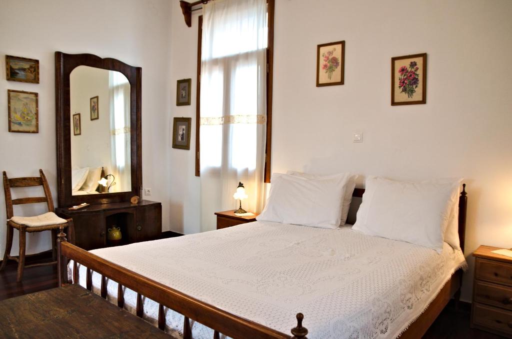 1 dormitorio con 1 cama grande y espejo en Villa Athina, en Megála Khoráfia