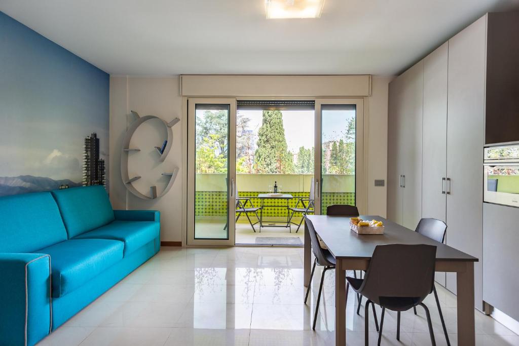 sala de estar con sofá azul y mesa en APPARTAMENTO MACIACHINI, ZONA ISOLA, en Milán